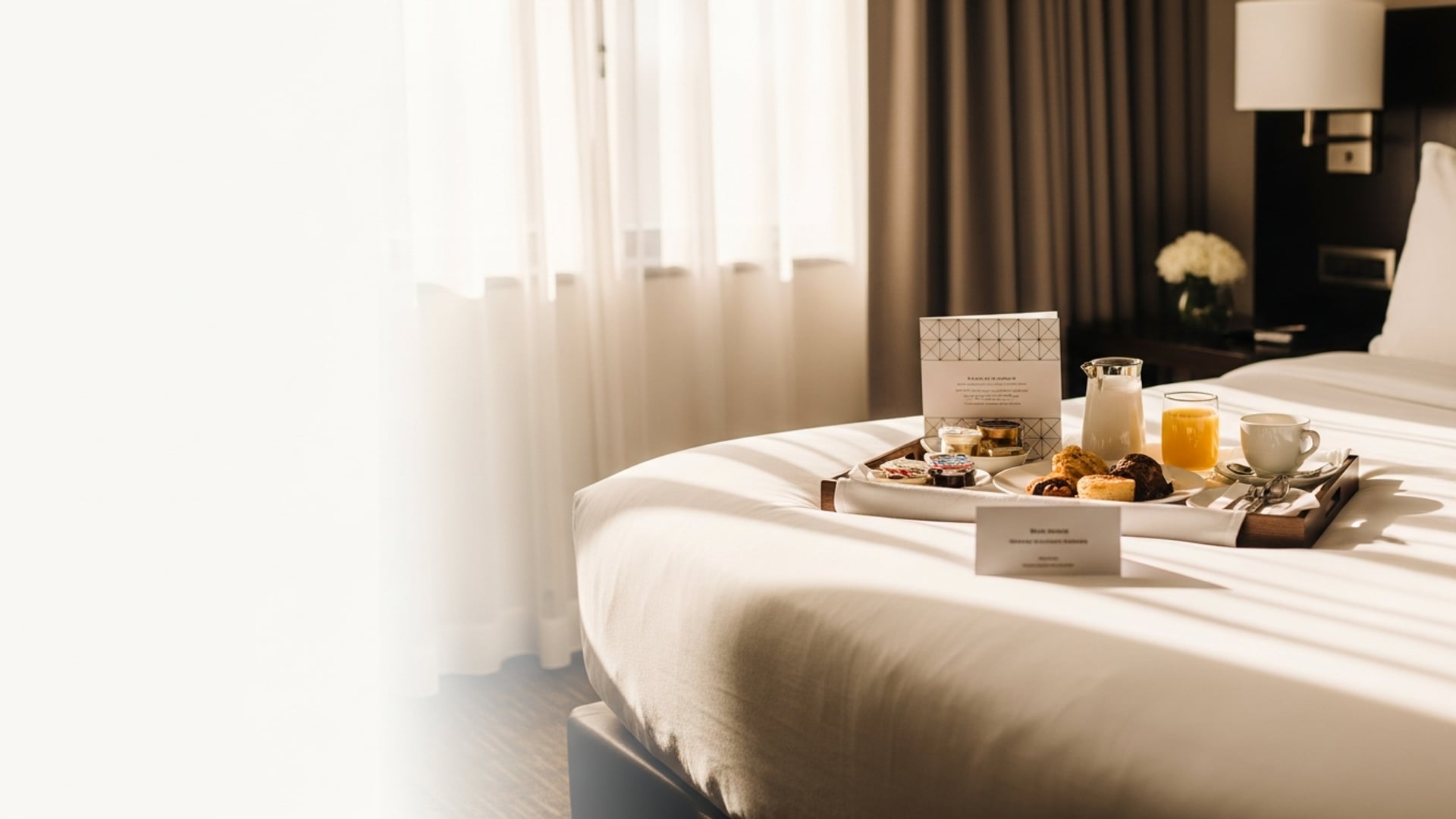 Bandeja de desayuno con una tarjeta de menú en la cama del hotel para pedir room service.