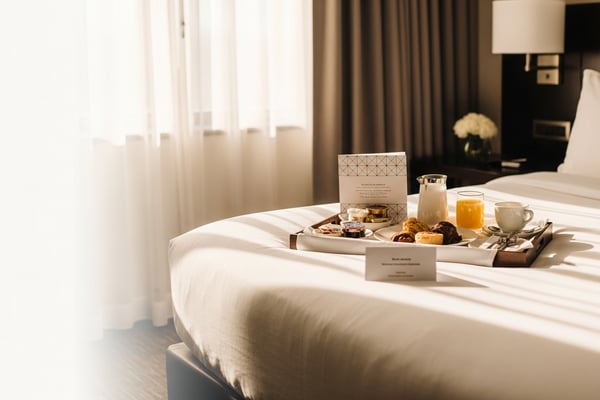 Bandeja de desayuno con una tarjeta de menú en la cama del hotel para pedir room service.